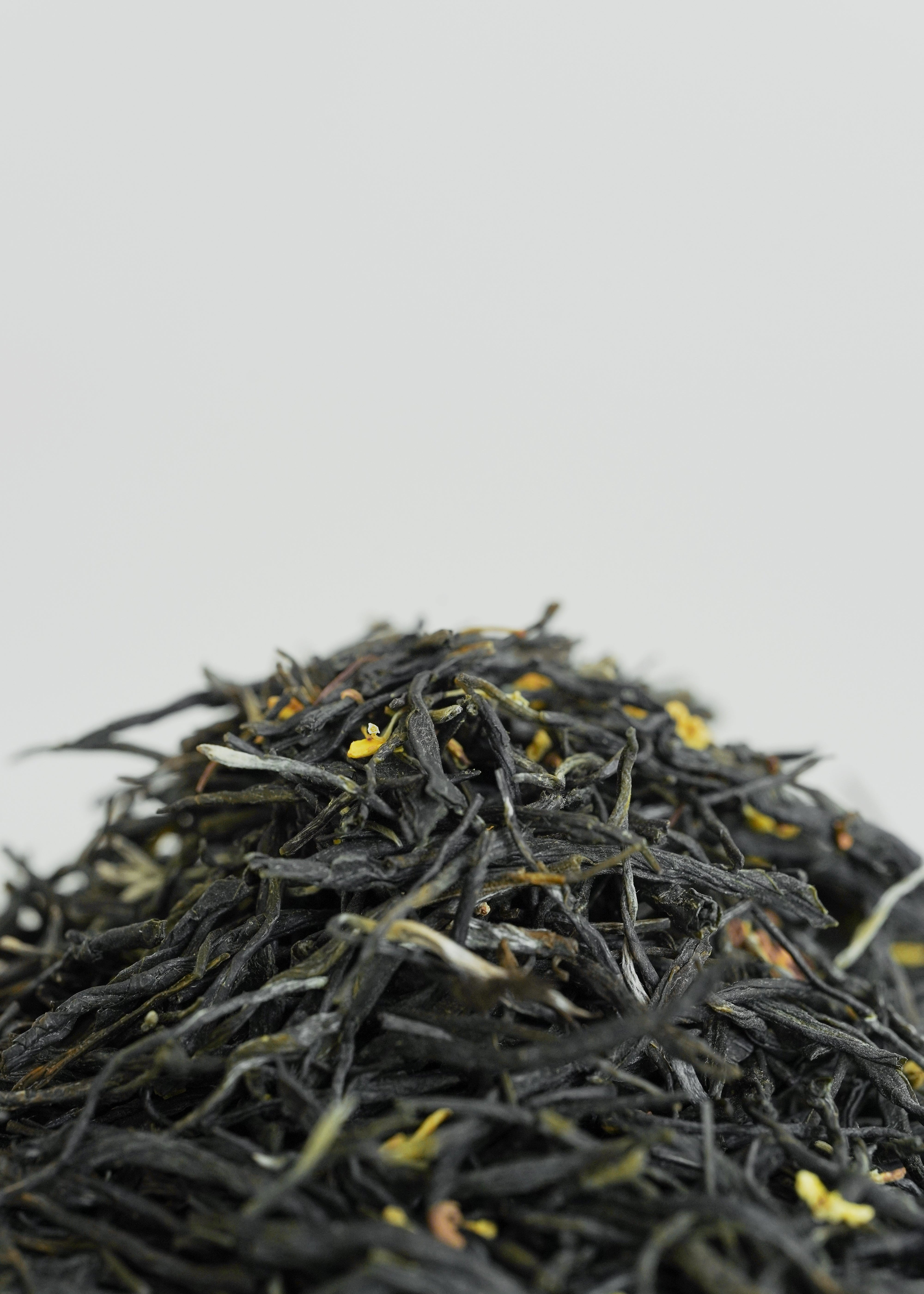 Close-up of green tea leaves with osmanthus on a white background