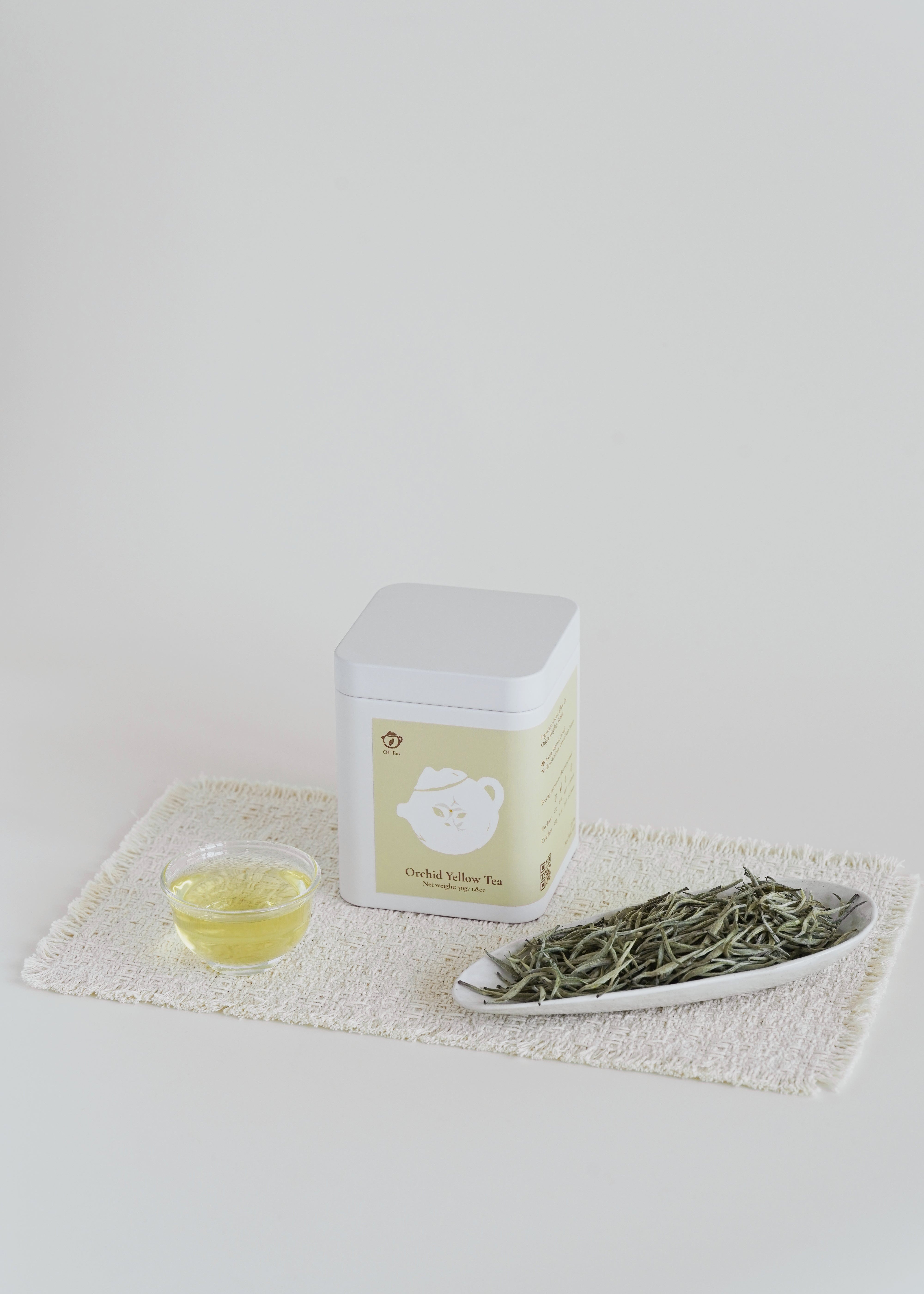 Tea packaging with a small bowl of tea leaves and a cup of tea on a white background. Orchid yellow tea