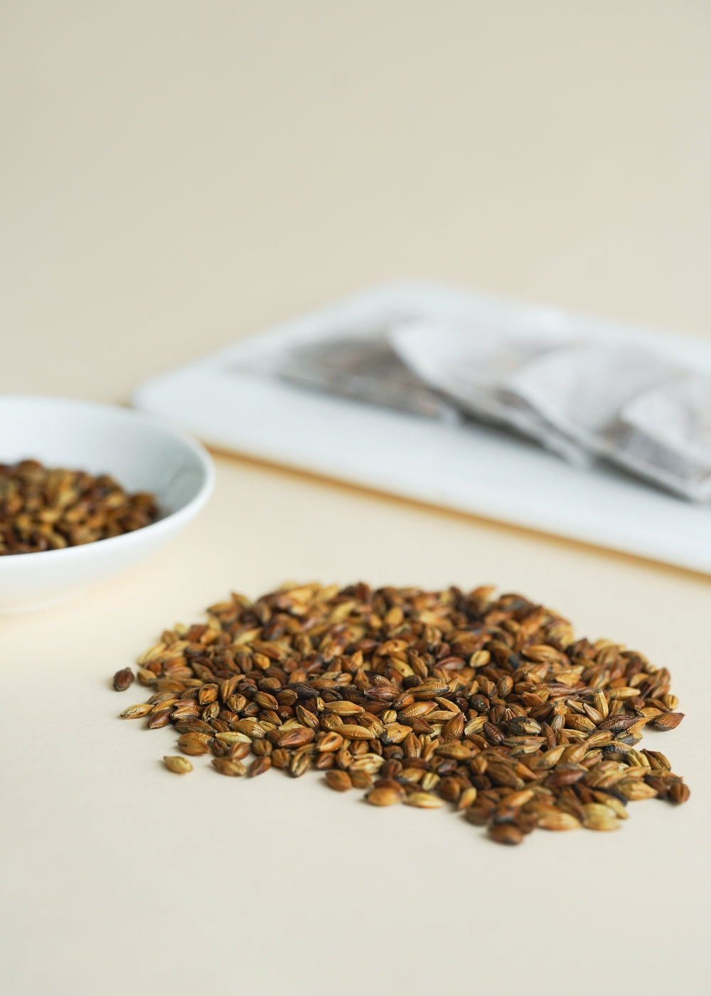 Spices on a wooden surface with a white bowl and gray cloth in the background