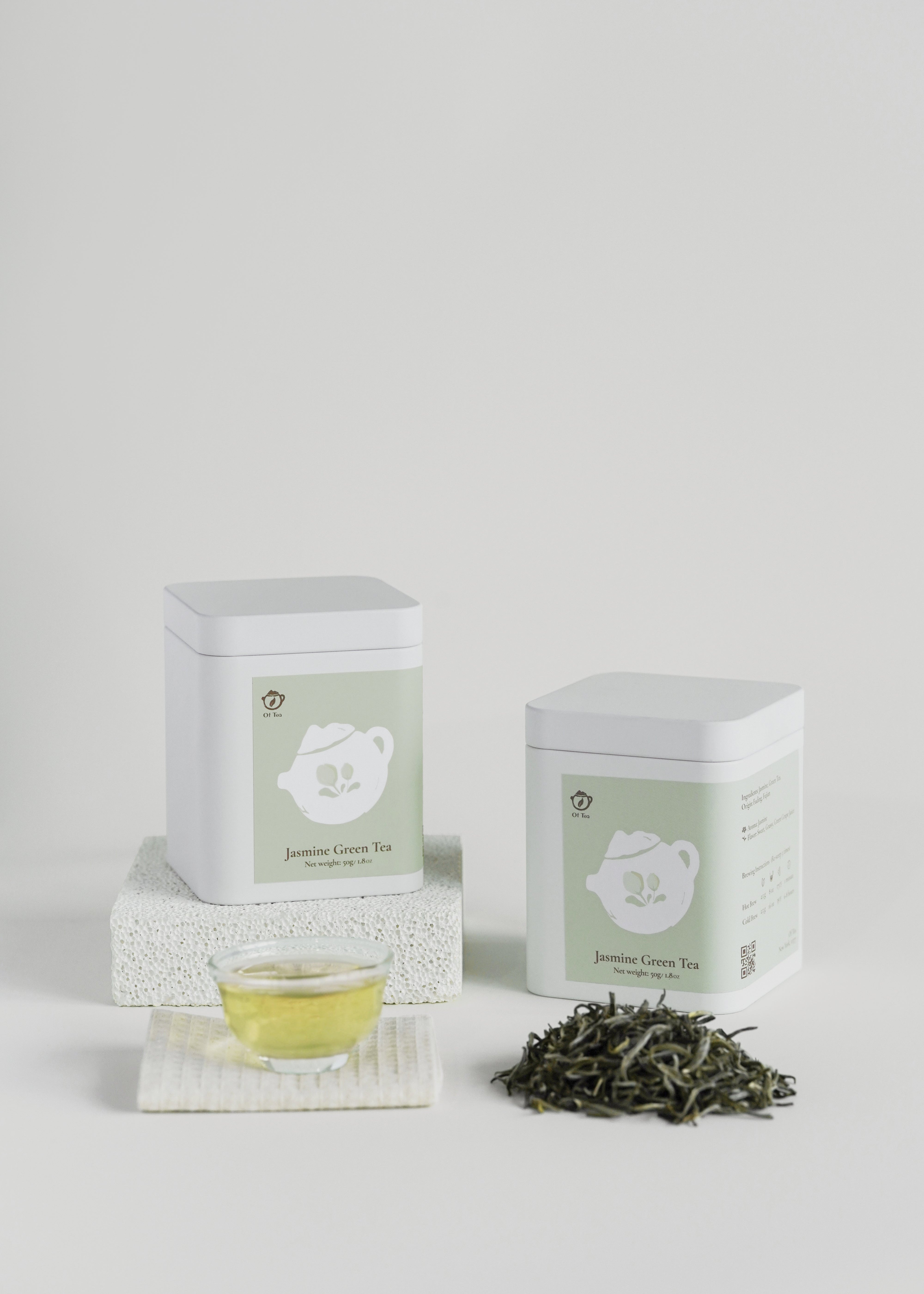 Tea packaging with a cup of tea and loose tea leaves on a white background. Jasmine green tea