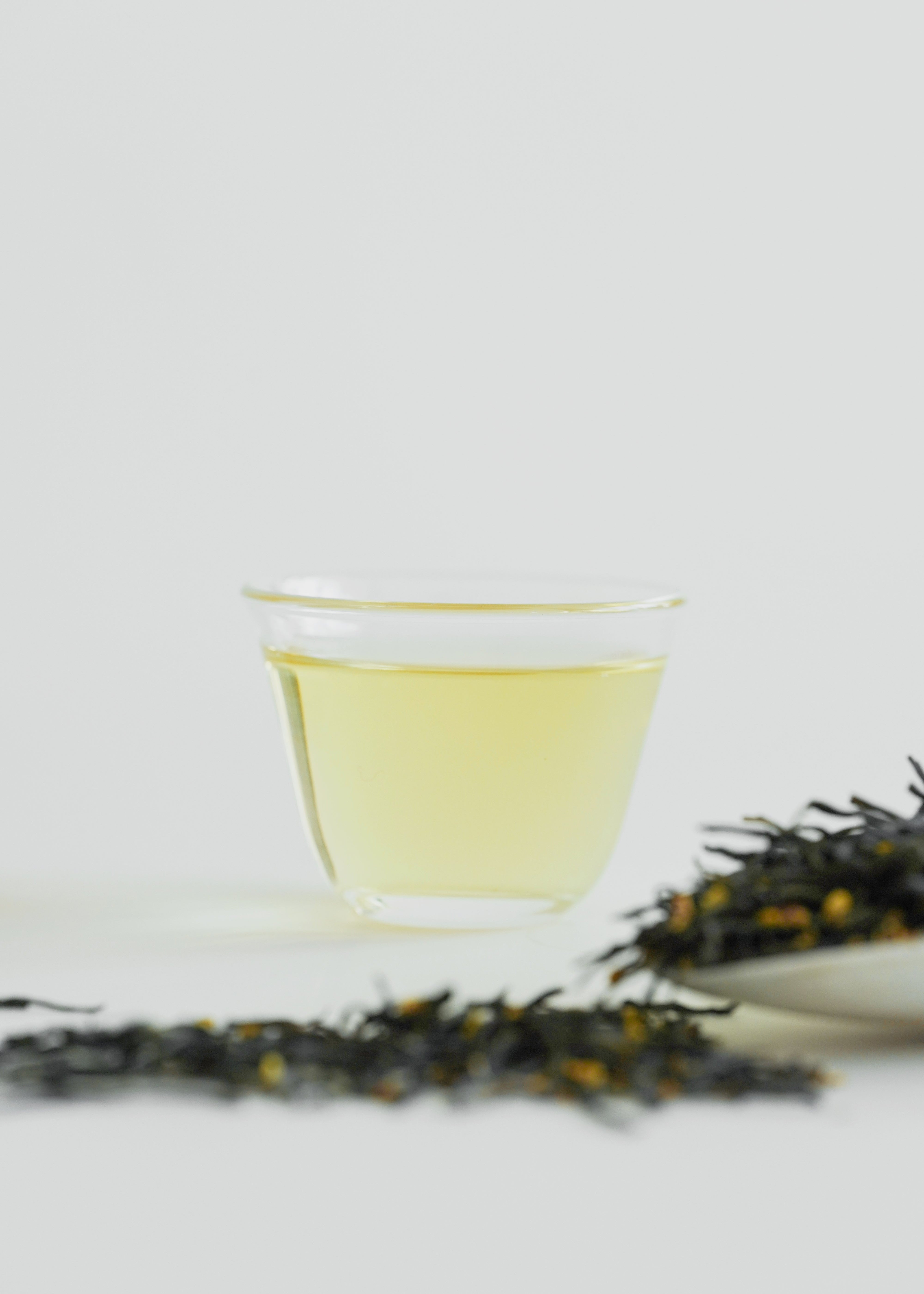 Tea leaves and a cup of tea on a white background. Osmanthus Green Tea