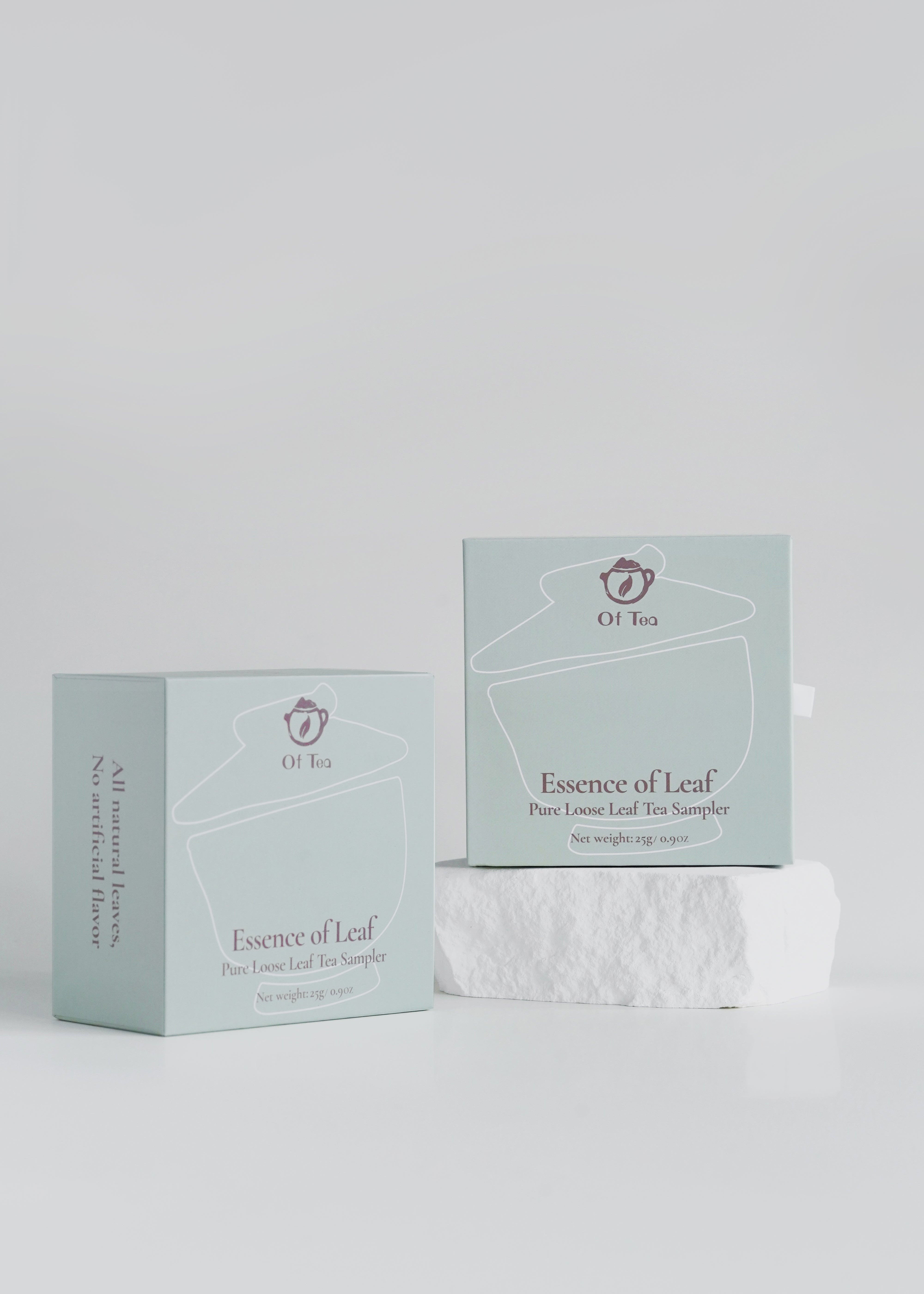 Two boxes of 'Essence of Leaf' tea on a light gray background