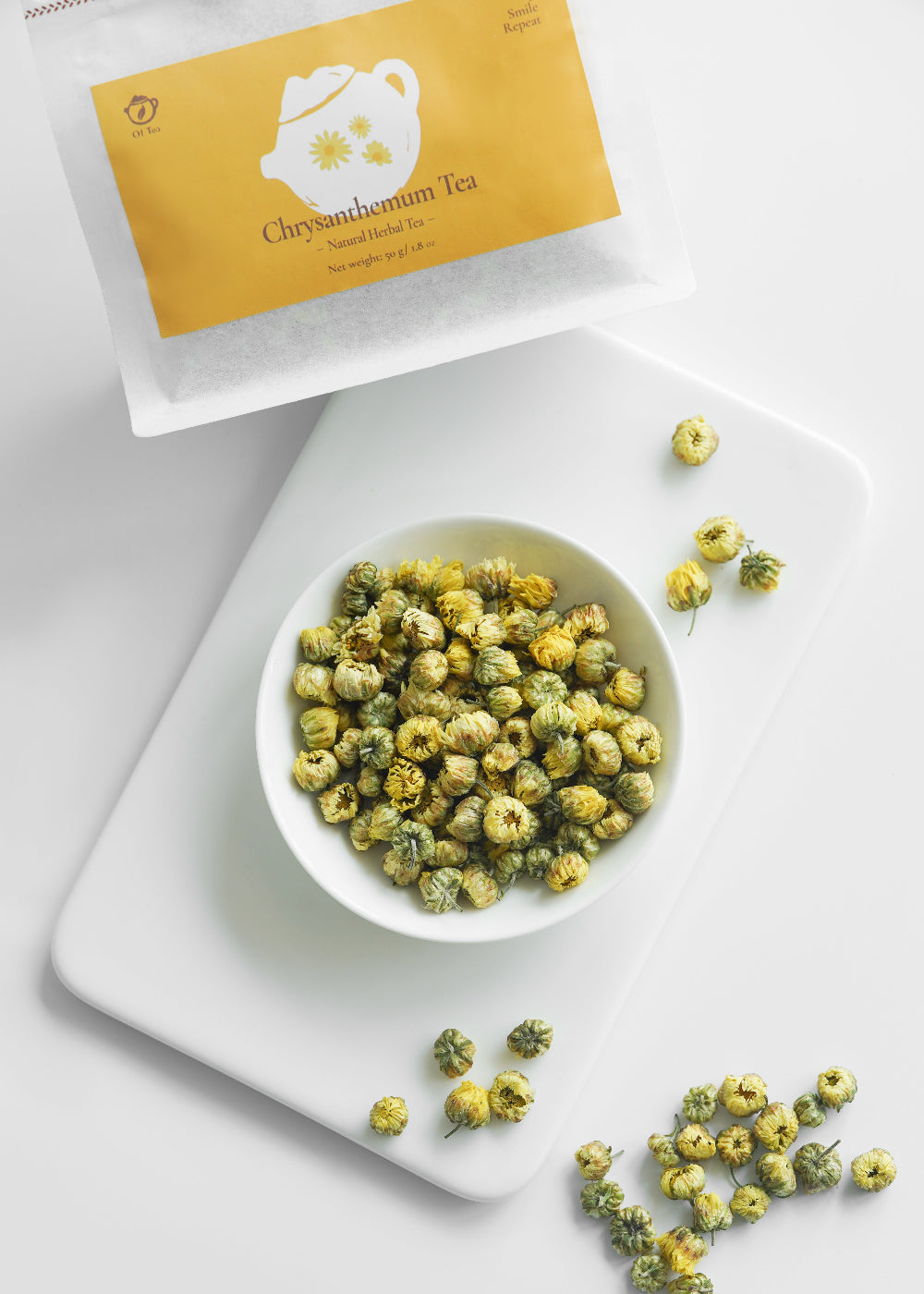 Bowl of dried herbs with a tea bag labeled 'Cheyuanmumu Tea' on a white surface.
